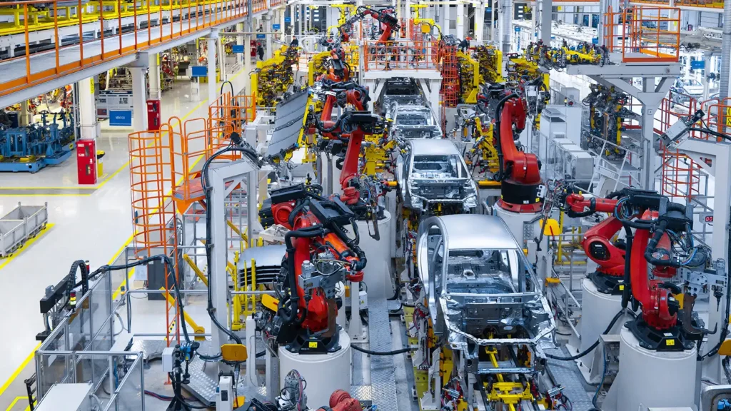 Automotive suppliers and factory workers handling vehicle components during ongoing supply-chain disruptions