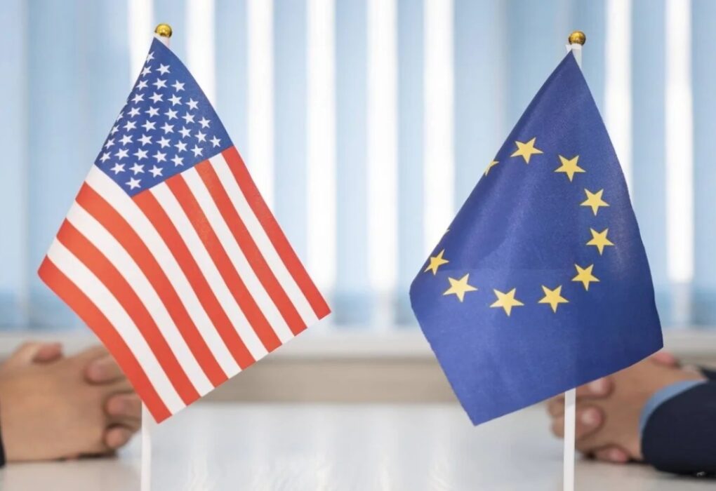 EU and US flags displayed during a high-level trade negotiation meeting symbolizing transatlantic economic relations.