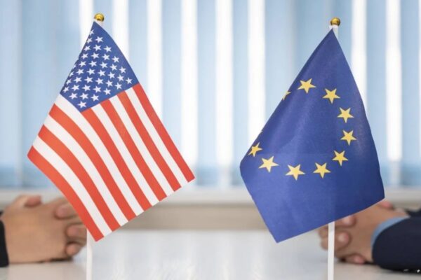 EU and US flags displayed during a high-level trade negotiation meeting symbolizing transatlantic economic relations.